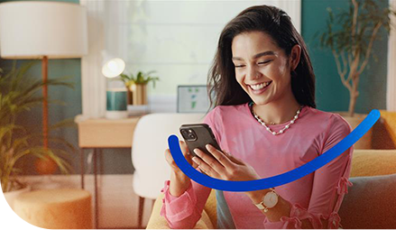 Mulher sorrindo olhando para o celular que esta em mãos